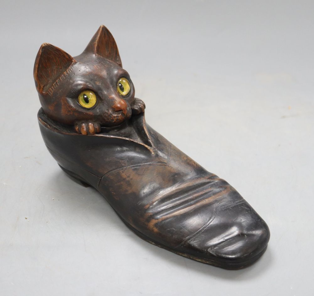 An early 20th century carved wood cat in a shoe inkwell, with hidden compartments, length 20cm